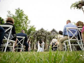 Wedding ceremony in front of the barn with guests seated on either side of the aisle, Lotus photo